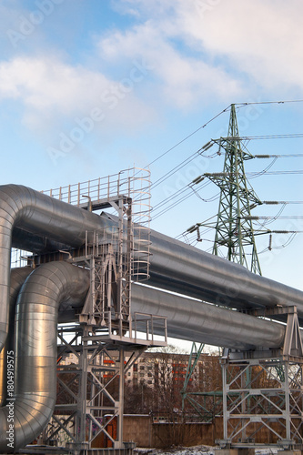 a pipeline and a power transmission tower against a blue sky.