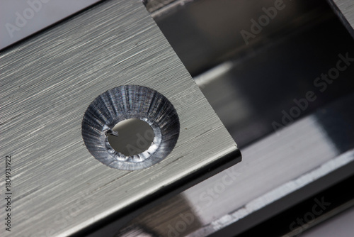 a countersunk milled hole in an aluminum facade profile in close-up. a macro photo of the production process. an illustration.