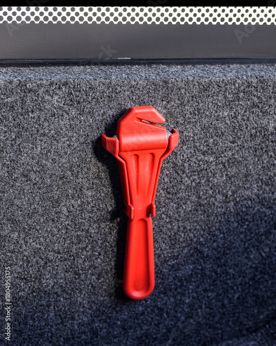 Red emergency hammer mounted inside a bus, highlighting public transport safety equipment.