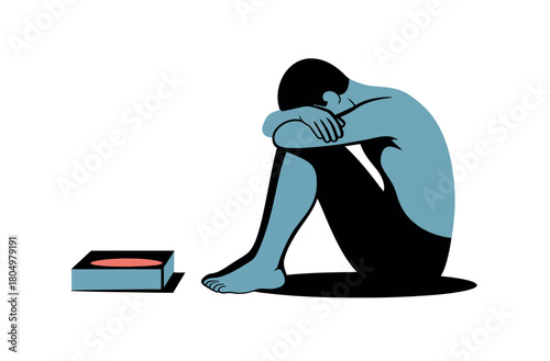 A person sits alone, hunched over with their head in their arms, next to an empty, low-profile food container, illustrating a feeling of emptiness or lack.