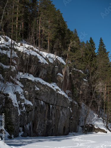 Rock formations on the shores of a frozen lake in winter in Finland