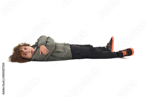   boy dressed in sportswear lying on the ground looking at camera and arms crossed on a white background