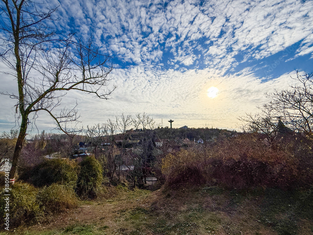 Obraz premium Sunlit village landscape with dramatic cloudscape 
