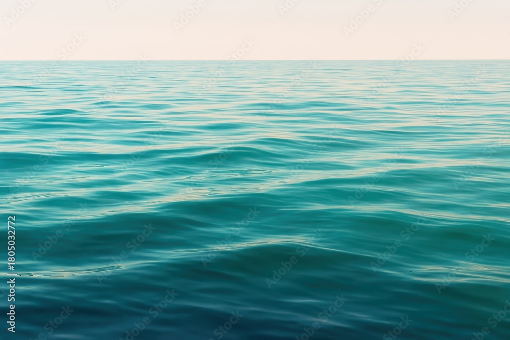 Fototapeta premium Tranquil turquoise ocean waves gently ripple under a soft, serene sky, evoking peace and boundless natural beauty for your next project.