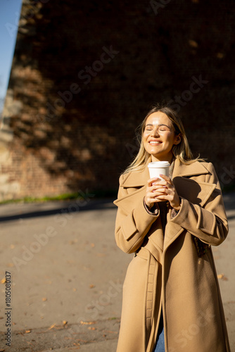 Young woman enjoys coffee o...