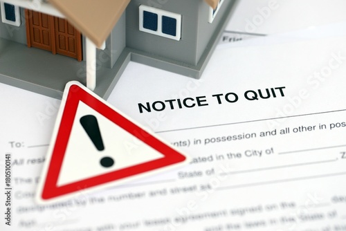Generic toy house and eviction notice or notice to quit on table close up