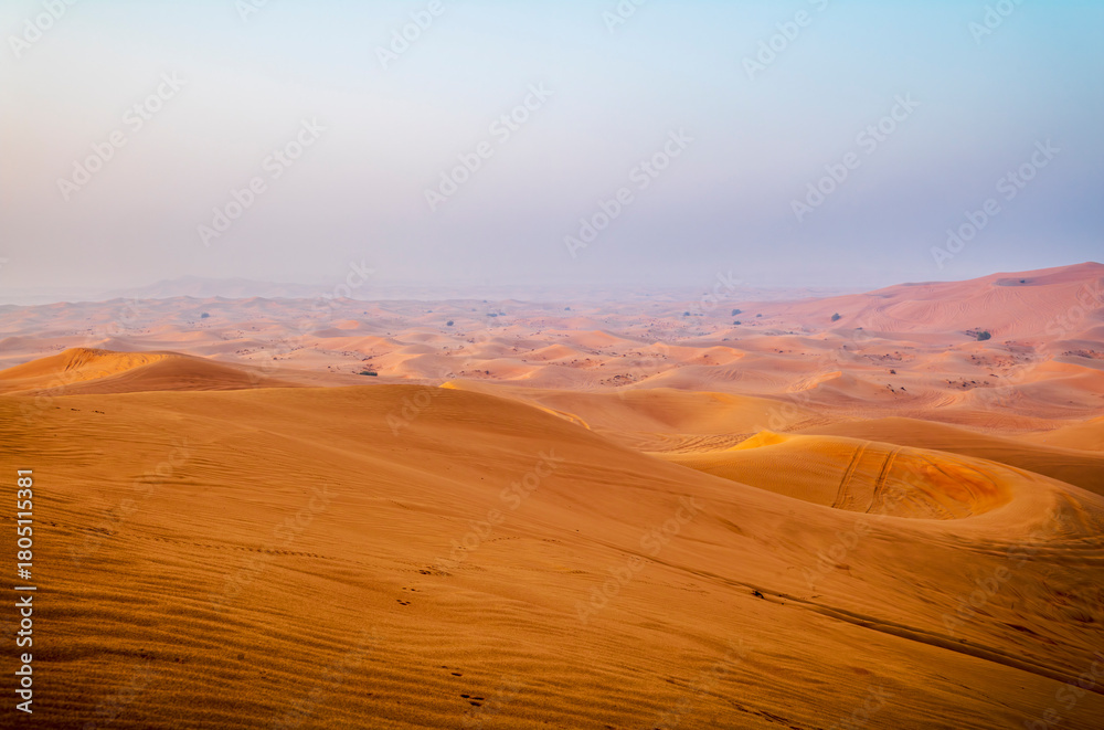 Naklejka premium The sun rising on the pristine and untouched red dunes in the desert near Dubai
