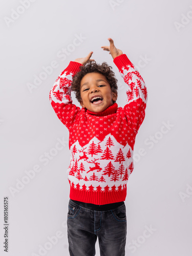 Foto little mulatto boy in a New Year's sweater on a white background in a studio