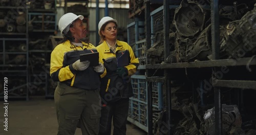 Industrial used car concept of 4k Resolution. Engineers are inspecting together in an old car spare parts factory.