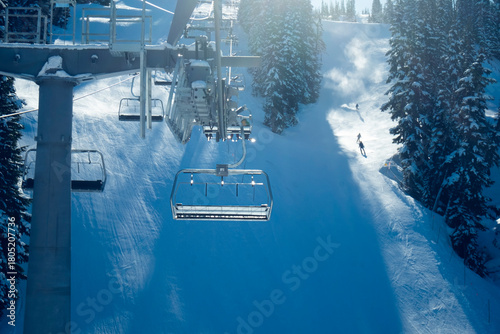 Empty ski lift with skiers in the background
