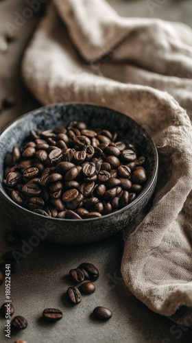 Freshly Roasted Coffee Beans in a Dark Bowl on a Textured Surface With a Fabr...
