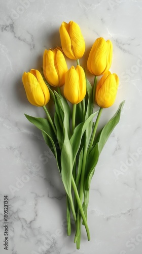 Bright Yellow Tulips Arranged Beautifully on a Marble Surface for Spring Deco...