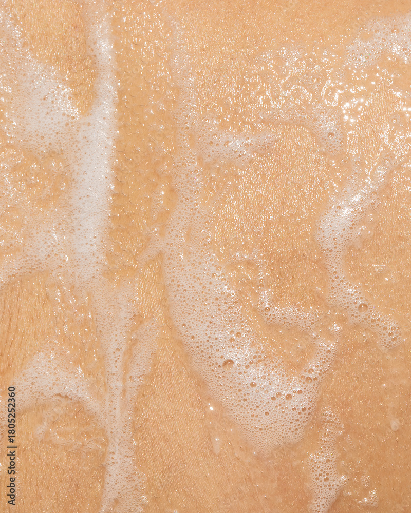 Fototapeta premium Macro photo of soapy foam texture on wet skin