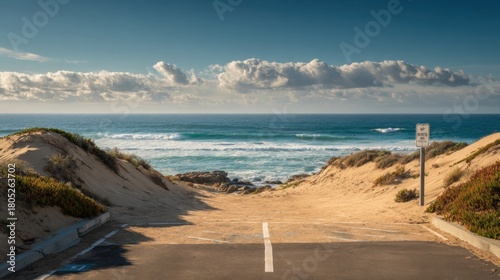 A beach with a sign that says no parking. The beach is empty and the sky is cloudy