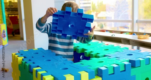 Child Building with Large Foam Blocks in Playroom