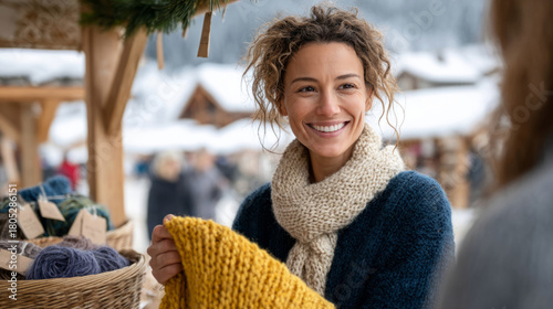 Woman enjoying winter market holding knitted scarf outdoors in snowy village