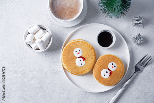 Pancakes with marshmallow snowmen in a plate for Christmas holidays