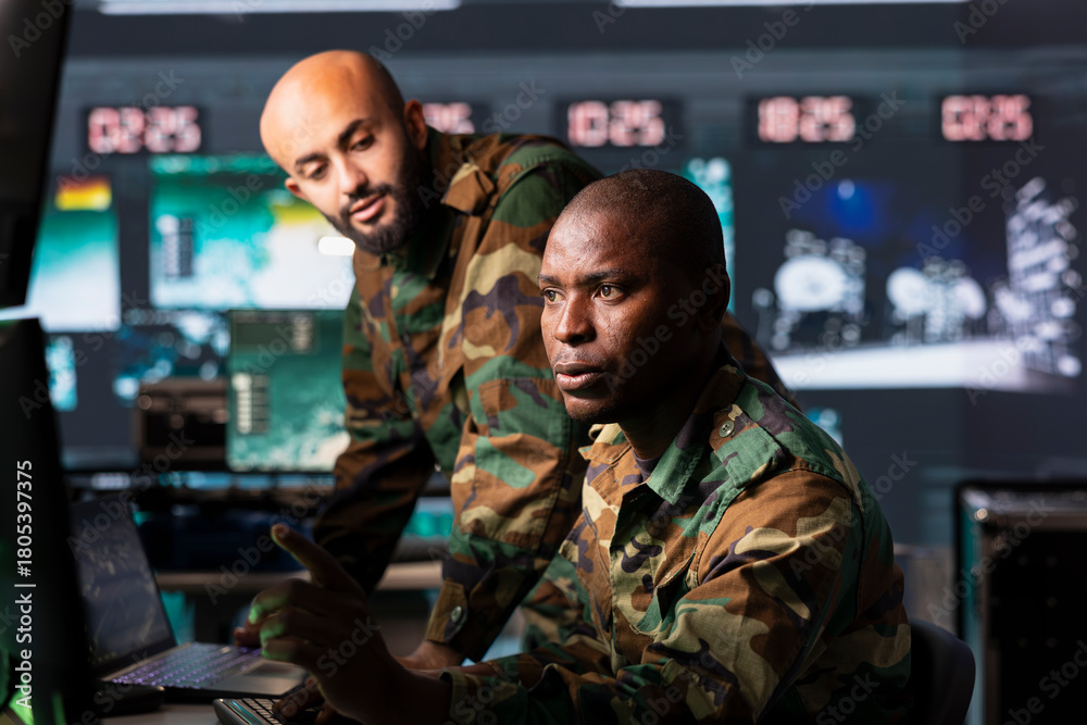 Fototapeta premium Military officer working on deployment of electronic warfare tools to disrupt enemy communications. Army soldier wearing camouflage uniform operating on high tech equipment