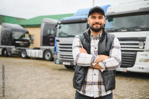 Foto Confident truck driver standing in front of transport fleet