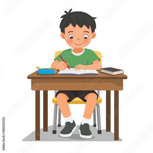 Little boy studying sitting at the desk writing on notebook doing homework