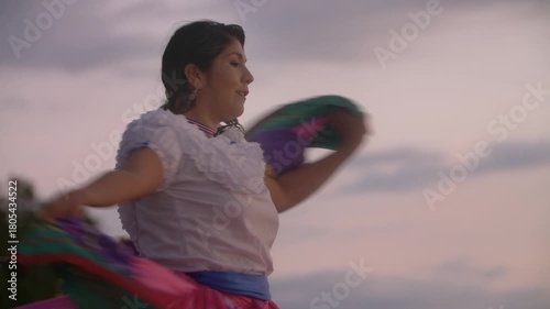 Slow motion video of Costa Rican woman in traditional Guanacaste dress dancing in sunset light at the beach