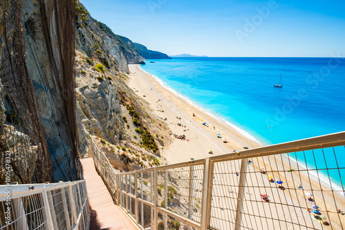 Path with stairs to amazing Egremni beach with tuquoise water and anchored bo...