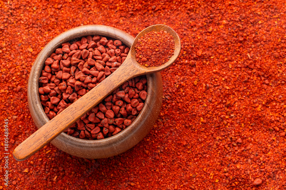 Fototapeta premium Crushed annatto seeds in the spoon and in the bowl - Bixa Orellana