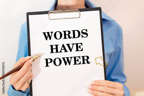 White paper with text Words have power lying on the keyboard.