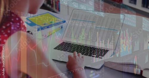 Typing student in red polka dot top at desk, laptop, books, notebook, charts, copy space