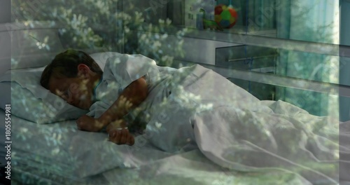 Sleeping child wearing white shirt lying on bed with white duvet, colorful ball, foliage overlay