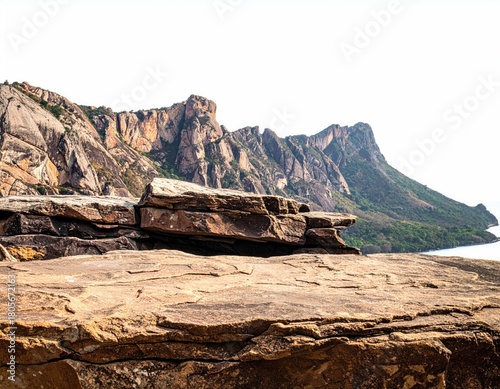 Rock outcropping overlooks majestic mountains and distant sea