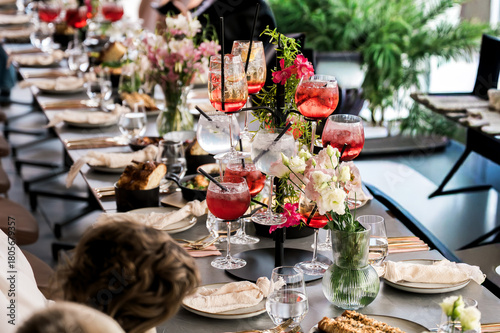 Valokuva Elegant banquet table set with vibrant cocktails, fresh floral arrangements, gou