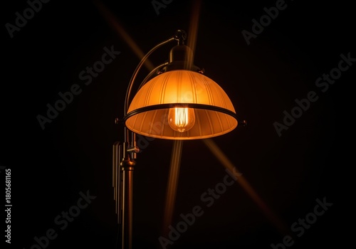 Dramatic low key photograph of a vintage brass floor lamp with a glowing edison bulb