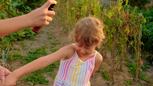 Child spraying mosquito repellent. Selective focus.