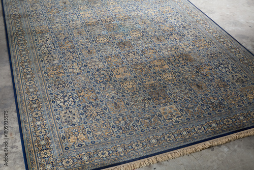 Overhead view of traditional Persian-style rug with blue and gold geometric pattern
