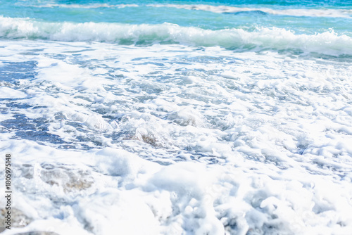 Foamy turquoise sea waves on the shore. Beautiful nature. Relaxation and tranquility. Background. Space for text.