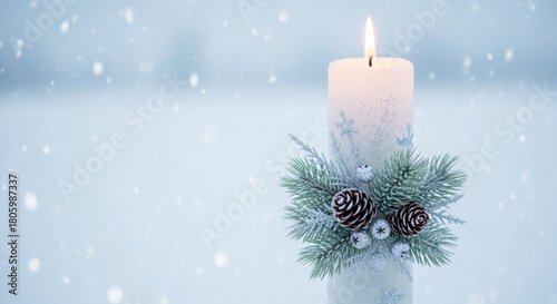 Burning white candle with snowflakes and a wreath on a snowy background with snowflakes falling in a winter scene for a festive holiday decoration