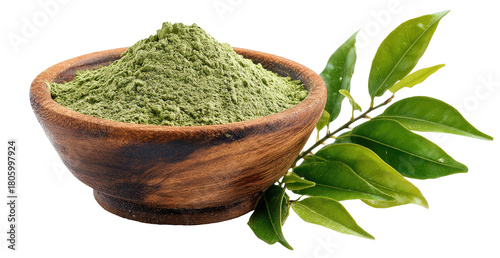 A wooden bowl filled with finely ground green powder beside a branch