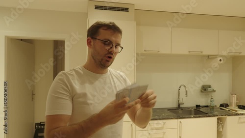 A man studies with flashcards in the kitchen — learning, repeating, and memorizing information for exams or self-improvement.