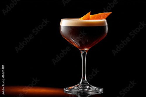 Elegant espresso martini with orange twist on black background, ready to enjoy the delicious and refreshing taste of this classic cocktail