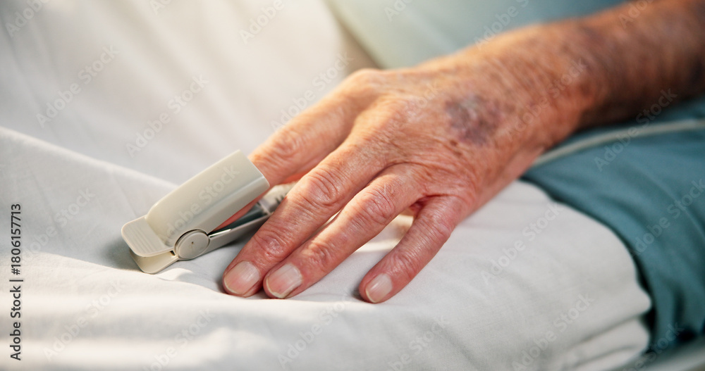 Obraz premium Hands, sick and old person with oximeter in hospital bed to monitor pulse, blood levels and post surgery. Closeup, elderly patient or medical device to track oxygen, chronic condition and operation