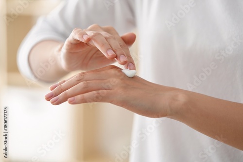 Person applying moisturizer to dry hands for hydration