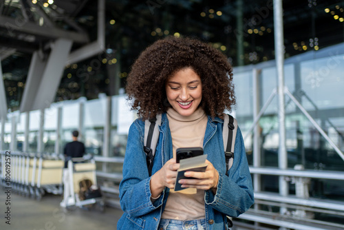 Latino woman chatting on phone while waiting public car outside airport. 