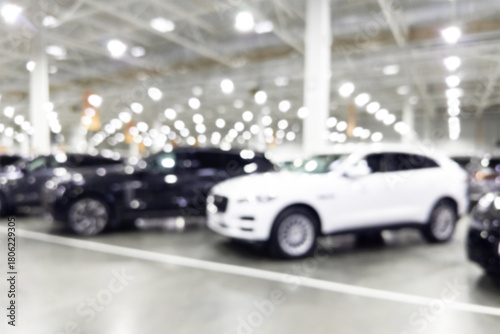Blurred background with car dealership store interior. Blurred abstract dealership store with defocused cars. Blur bokeh transportation concept dealer showroom