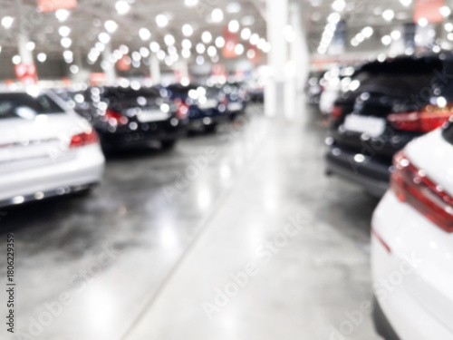 Blurred background with car dealership store interior. Blurred abstract dealership store with defocused cars. Blur bokeh transportation concept dealer showroom