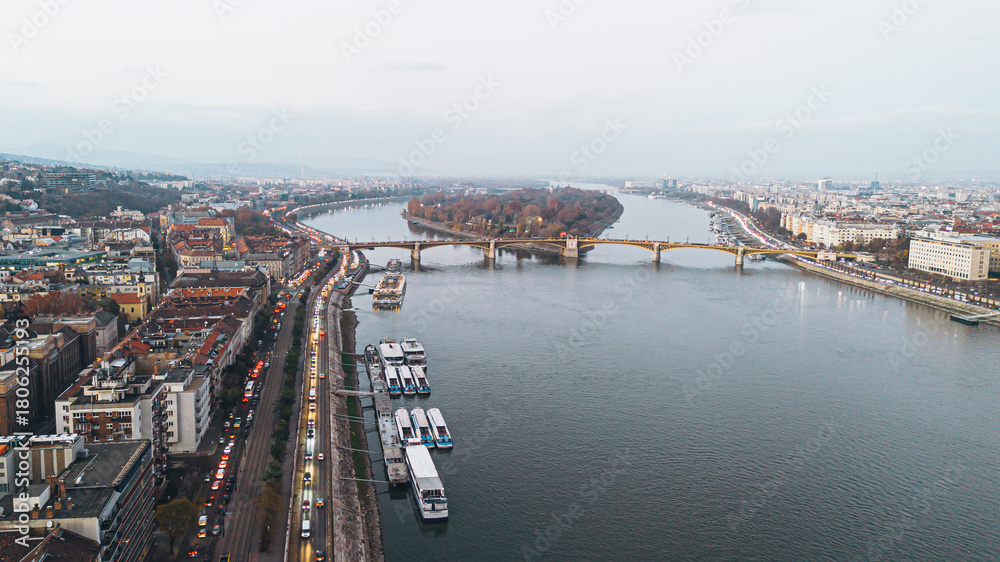Obraz premium Scenic cityscape of Budapest, Hungary, featuring the Danube River, Margaret Bridge, and bustling urban life.