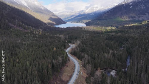 Winding Road Through Forest Leads to Lake and Snow-Capped Mountains in British Columbia, Canada