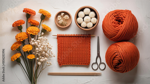 - Flat lay knitting supplies with orange yarn for crafting