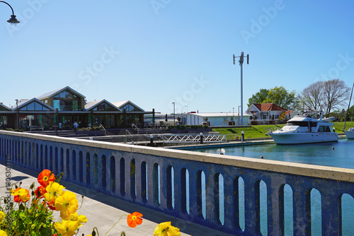A view from the Kaiapoi River Bridge towards the Wharf on a clear blue spring day with flowers in the foreground.