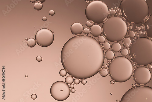 Closeup macro shot of oil bubbles in water with a soft brown background